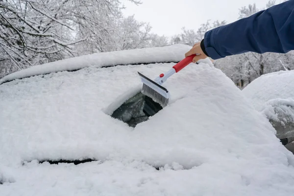 The drivers hand creaning the car from snow in the morning before the journey — Stock Photo, Image