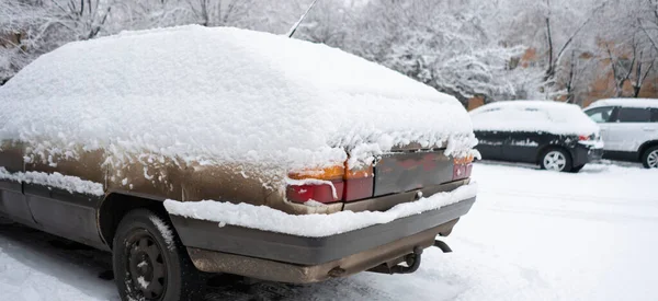 Машина покрыта снегом утром на стоянке в зимний сезон — стоковое фото