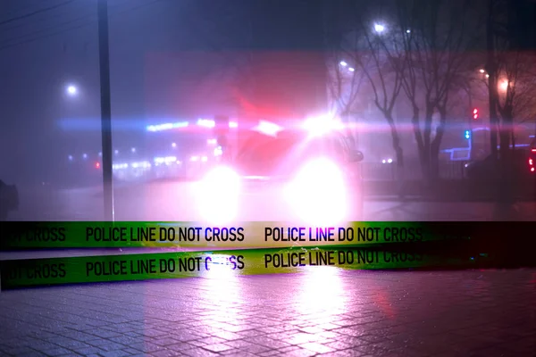 A police line do not cross ribbon in front of the police car in the night — Stock Photo, Image