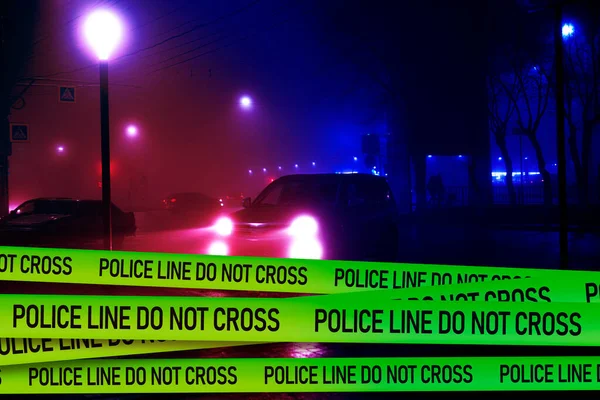 Una línea de policía no cruzar la cinta delante del coche de policía en la noche — Foto de Stock