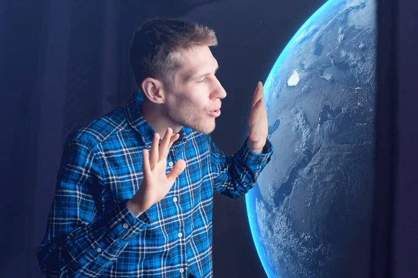 Un jeune touriste spatial masculin regardant par la fenêtre d'un vaisseau spatial et admirant les étoiles et les planètes de la galaxie. éléments de cette image fournis par nasa — Photo