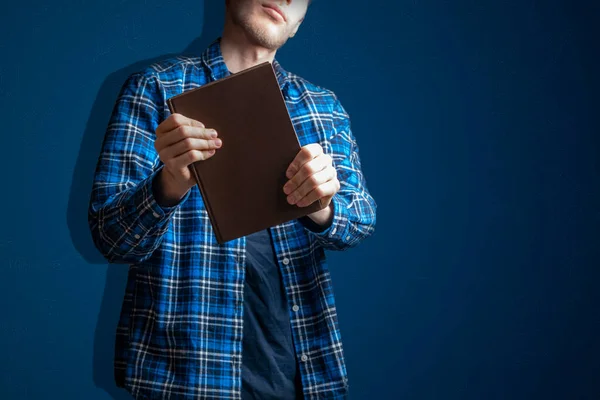 Um jovem segurando e dando um livro, compartilhando conhecimento e sabedoria — Fotografia de Stock