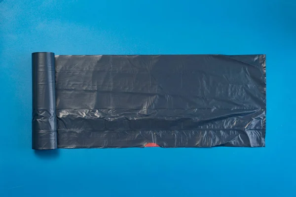 Nuovo rotolo nero sacchetto della spazzatura sulla superficie colorata, isolato, cura del pianeta — Foto Stock