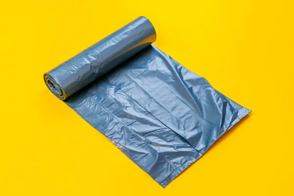 Nuevo rollo de bolsa de basura negro en la superficie colorida, aislado, cuidar el planeta — Foto de Stock