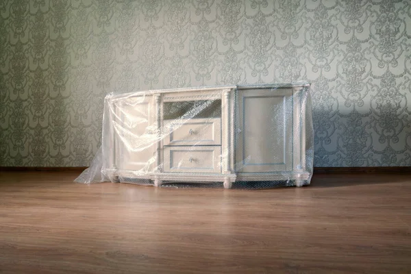 Új bútorok szállítása az új lakás a műanyag védőanyag — Stock Fotó