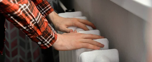 Die gefrorenen Hände berühren im Winter zu Hause eine Heizbatterie — Stockfoto