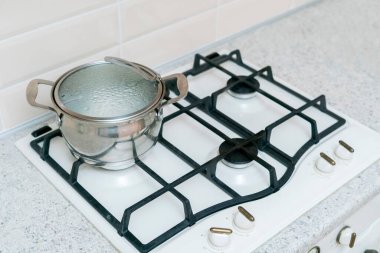 Mutfakta yemek pişirirken içinde kaynar su olan basit bir tencere.