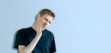 Basit kopyalama alanı, diş ağrısının minimum konsepti, renkli duvara karşı erkek biçimi