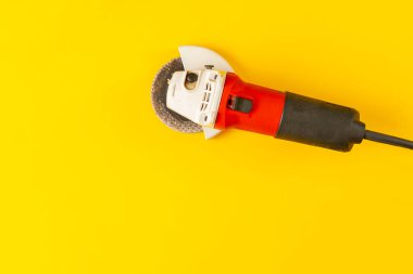 Renkli yüzeye karşı izole edilmiş basit bir siyah ve kırmızı açı öğütücü makine aracı