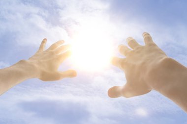 Bir insan eli gökyüzünden gelen güneş ışığından kendini korur.