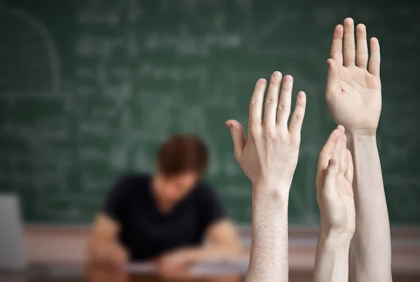 a group of pupil raise hand and want to answer the teachers question, blackboard background