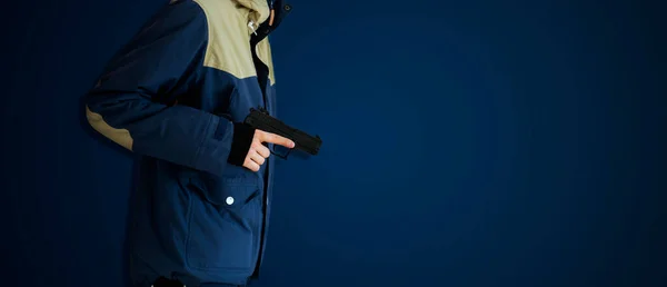Egy bűnöző bandita egy kis fekete pisztollyal elszigetelve a színes faltól, egyszerű elvont törvényen kívüli fogalom, másolja a helyet — Stock Fotó