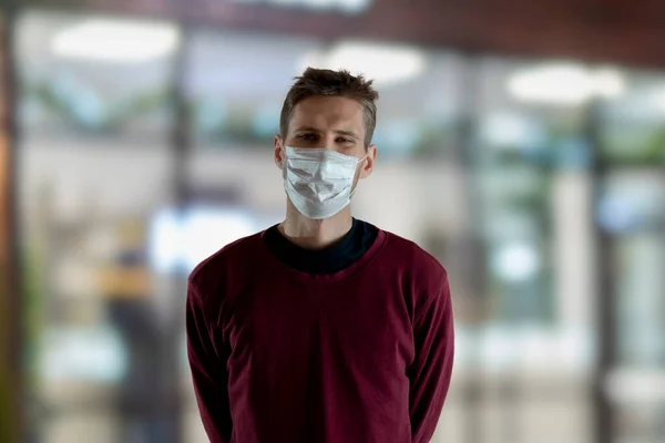 Um homem vestindo uma máscara facial protetora durante a pandemia de coronavírus ao ar livre na rua pública — Fotografia de Stock