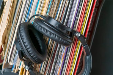 Koyu renkli kulaklıklar eski plakların üzerinde duruyordu.