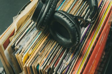 Koyu renkli kulaklıklar eski plakların üzerinde duruyordu.