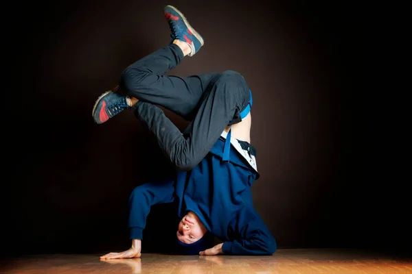 Hip hop tancerz wykonać headstand do góry nogami w ciemnym studio b — Zdjęcie stockowe