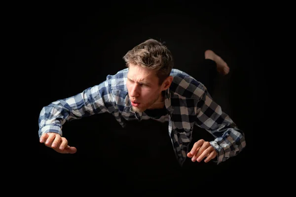 Привлекательный испуганный мужчина падает с высоты на темном фоне b — стоковое фото