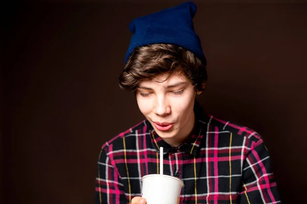 Young male drink lemonade on dark background isolated f — Stock Photo, Image