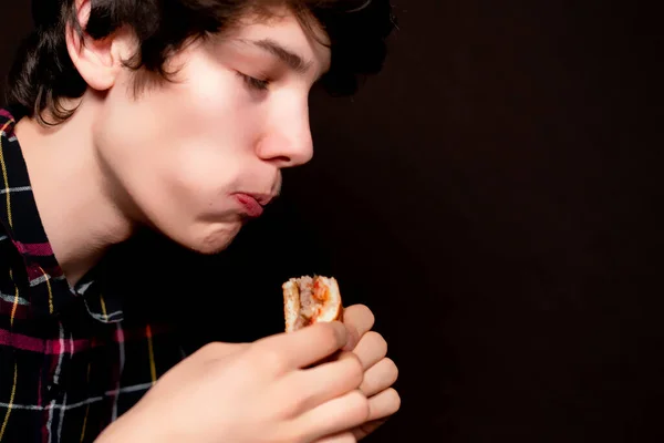 Closeup photo of young man chew junk food on dark background b — Stock Photo, Image