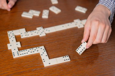 Domino taşını ahşap masanın üzerinde tut.