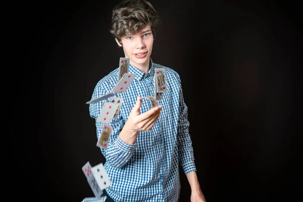 Fiatal férfi illuzionista dobás kártya sötét háttér izolált b — Stock Fotó