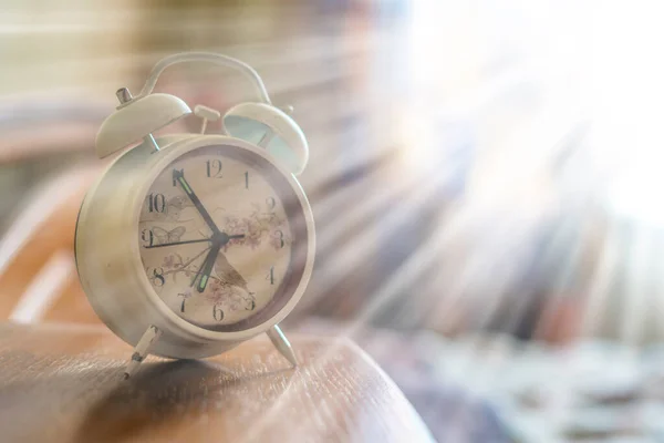 Relógio de alarme retro branco na mesa de cabeceira na manhã f — Fotografia de Stock