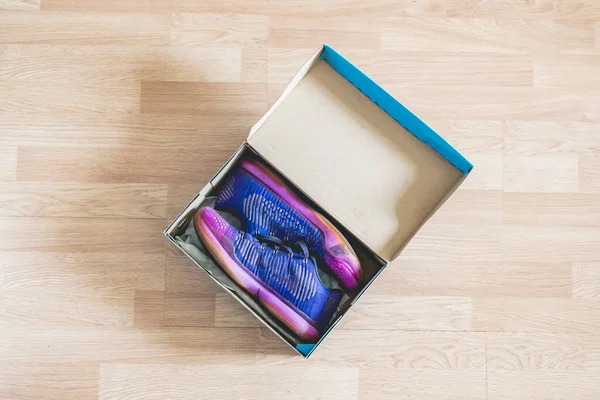 Пара новых ботинок в коробке из-под обуви на деревянном полу — стоковое фото