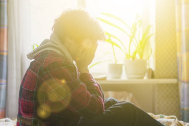 Üzgün, yalnız bir ergen yatak odasında sorun yaşıyor ve ağlıyor.