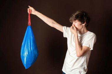 Çekici erkek, pis kokulu çöp torbası tutuyor. çöp konseptini çıkar