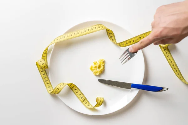 Persoon handen met vork en mes eten kleine portie voedsel. anorexia b — Stockfoto