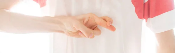 Person drückt die Daumen hinter dem Rücken b — Stockfoto