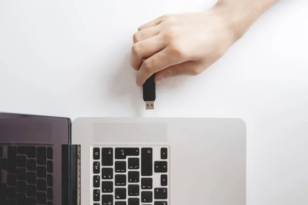 Macho de la mano conectar la unidad flash USB en un dispositivo portátil b —  Fotos de Stock