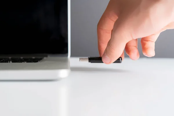 Macho de la mano conectar la unidad flash USB en un dispositivo portátil b —  Fotos de Stock