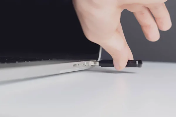 Mão masculina conectar usb flash drive em um dispositivo laptop b — Fotografia de Stock