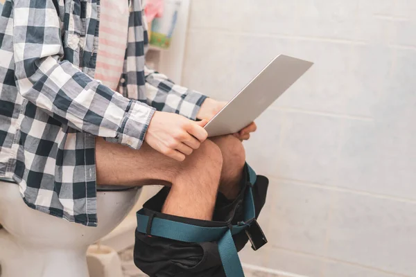 Buisnessman sentarse en el inodoro y trabajar con el ordenador portátil en el baño d — Foto de Stock