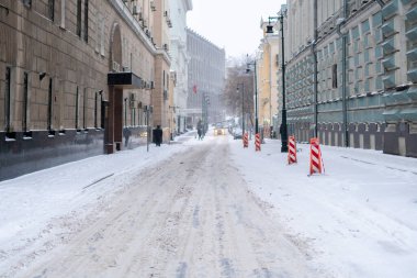 Şehrin yan sokaklarında. Sisli bir gün. Kış şehrinde ıssız sokak karı.