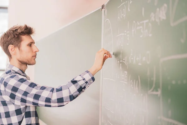 Las personas sostienen la tiza y escriben cálculos matemáticos en un tablero b — Foto de Stock