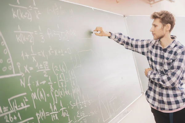 Pessoas mão segurar giz e escrever cálculos matemáticos em um quadro b — Fotografia de Stock