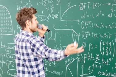 Üniversitede öğretim görevlisi öğrencilere bilgi veriyor.