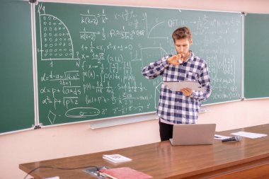 Genç profesör B tahtasında teoremi kanıtlıyor.