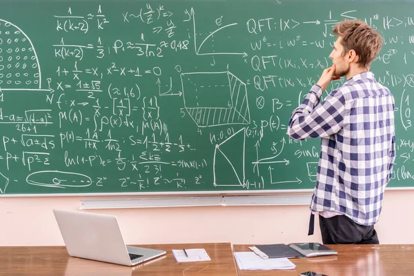 Jovem professor provando teorema em um quadro negro b — Fotografia de Stock