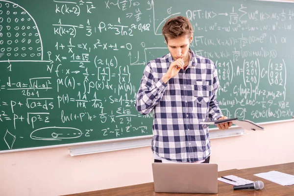 Jovem professor provando teorema em um quadro negro b — Fotografia de Stock