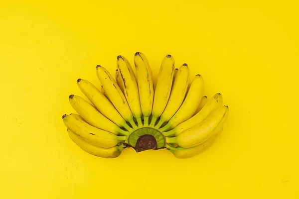 Een rijpe trendy klaar om te eten lelijke bos van mini bananen met zwarte stippen op gele ondergrond — Stockfoto