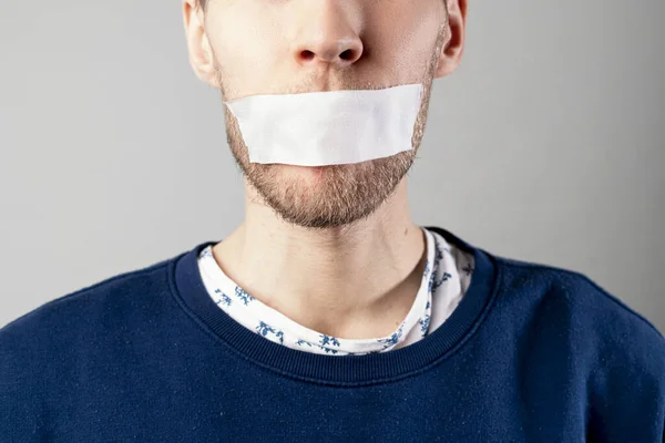 Un el hombre con una cinta cerrar la boca, dejar de hablar y apagar, concepto de censura, — Foto de Stock
