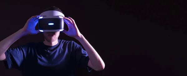 Egy virtuális valóság üveg készlet sötét, férfi személy segítségével innovatív futurisztikus modul neon fények — Stock Fotó