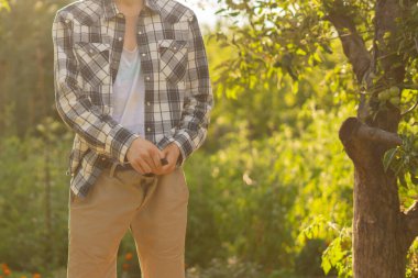 rear view of young person standing outdoor and piss under the trees