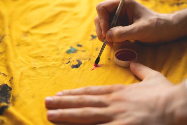 Tişörtünde fırça olan bir resim, kendine has kıyafet tasarımı kavramları.