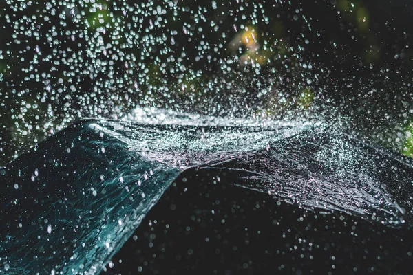 Zavřít černý deštník s cákancemi a kapkami deště během silného deště venku — Stock fotografie