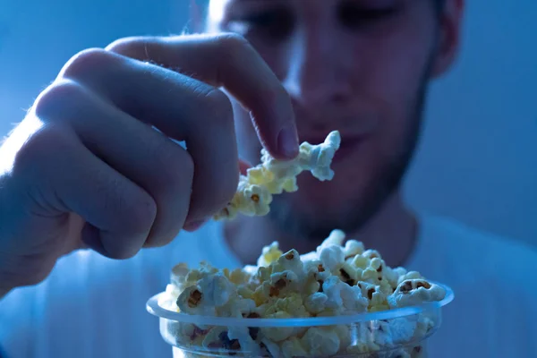 Close up young male holding popcorn to put it in his mouth — 스톡 사진