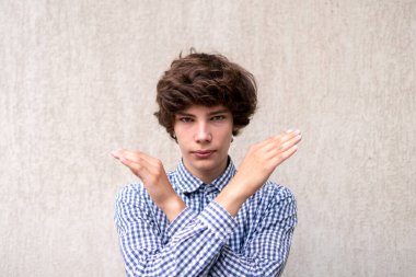 Elleri çapraz olan genç adam, dur işareti.